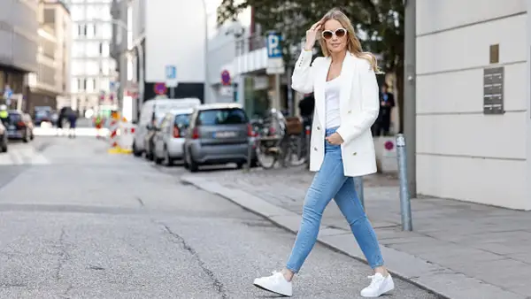 woman wearing blue skinny jeans and white blazer