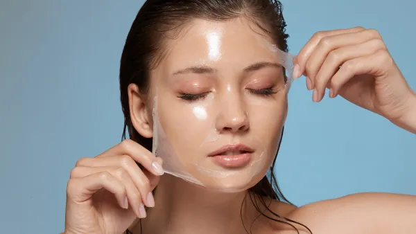 pretty female taking off purifying mask with her eyes closed, girl with wet hair removing moisturizer, fresh and clean skin