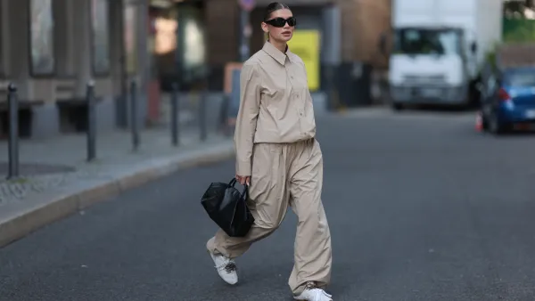 BERLIN, GERMANY - SEPTEMBER 18: Sophia Geiss seen wearing Mango black sunglasses, Layerplan beige cotton buttoned shirt, matching Layerplan beige long pants, Cos black leather bag and New Balance x Miu Miu white / beige leather sneakers, on September 18, 2024 in Berlin, Germany. (Photo by Jeremy Moeller/Getty Images)