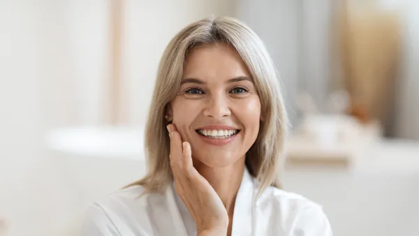 Closeup of attractive blonde woman touching her face