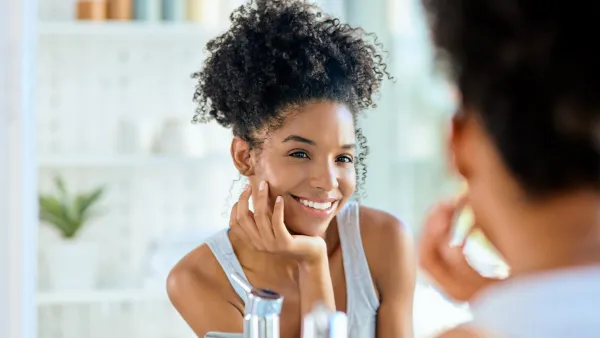 Shot of an attractive young woman admiring herself in the bathroom mirror during her morning beauty routine