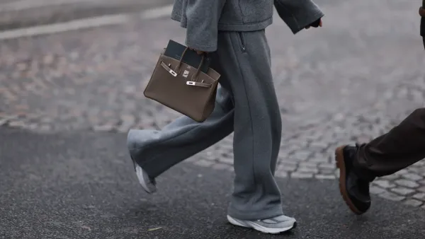 PARIS, FRANCE - JANUARY 25: Fashion Week Guest seen wearing a grey jogging suit, jacket, wide jogging pants and sport sneaker, Hermes taupe Birkin bag outside Hermes Show, during the Menswear Fall Winter 2025/2026 as part of Paris Fashion Week on January 25, 2025 in Paris, France. (Photo by Jeremy Moeller/Getty Images)