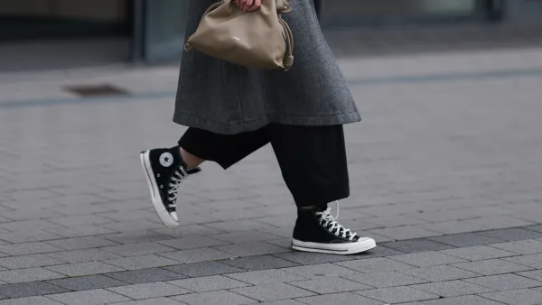 DUESSELDORF, GERMANY - NOVEMBER 08: Maria Barteczko is seen wearing oversized square-shaped aviator glasses with a black frame and narrow silver temples from Victoria Beckham; small chunky hoop earrings in silver from COS; an oversized grey wool coat with notch lapels and large pockets from WENDKYKEI; underneath a black t-shirt with a round neckline paired with black wide-legged culotte pants, both from WENDYKEI; a “Flamenco“ clutch bag in light khaki leather from Loewe; and black high top “All Star Chucks“ from Converse on November 08, 2024 in Duesseldorf, Germany. (Photo by Jeremy Moeller/Getty Images)