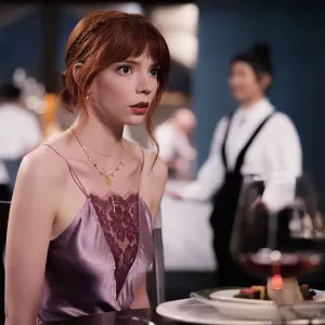 Anya Taylor-Joy sits at a table in The Menu.