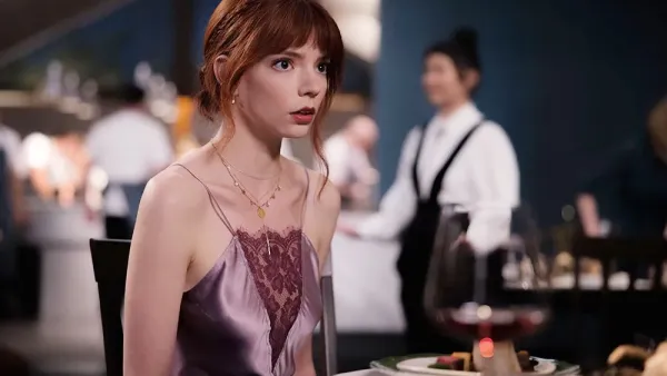 Anya Taylor-Joy sits at a table in The Menu.