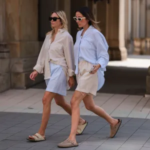 women in shorts and button up tops wearing sandals