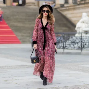 woman in red and black flowy dress and black hat