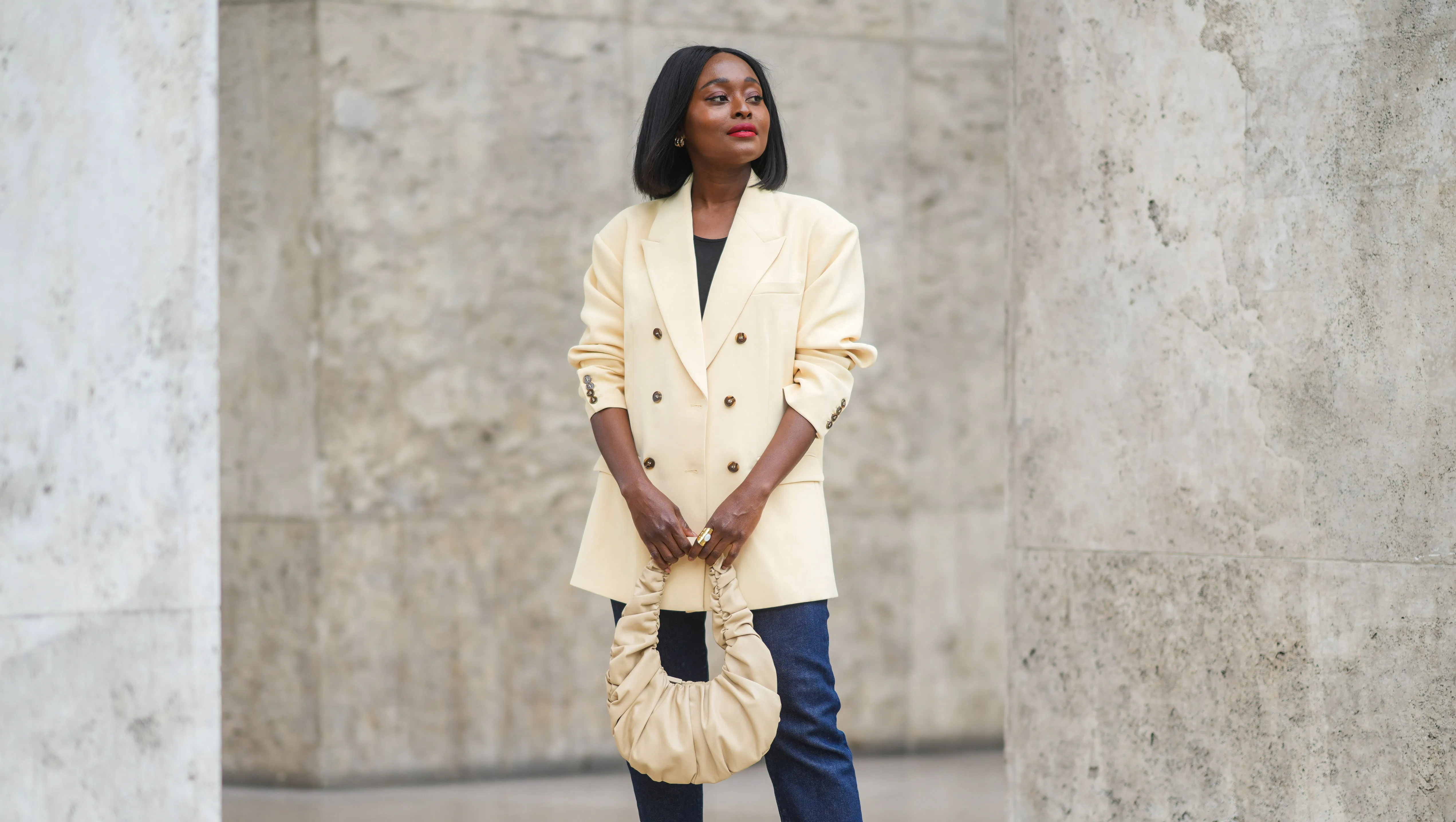 PARIS, FRANCE - JUNE 29: Carrole Sagba @linaose wears a beige oversized blazer jacket, a black top, blue denim jeans pants, a beige leather bag, a golden ring, yellow platform shoes, on June 29, 2021 in Paris, France. (Photo by Edward Berthelot/Getty Images)