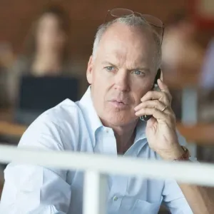 Michael Keaton holds a phone in Spotlight.