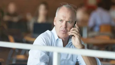 Michael Keaton holds a phone in Spotlight.