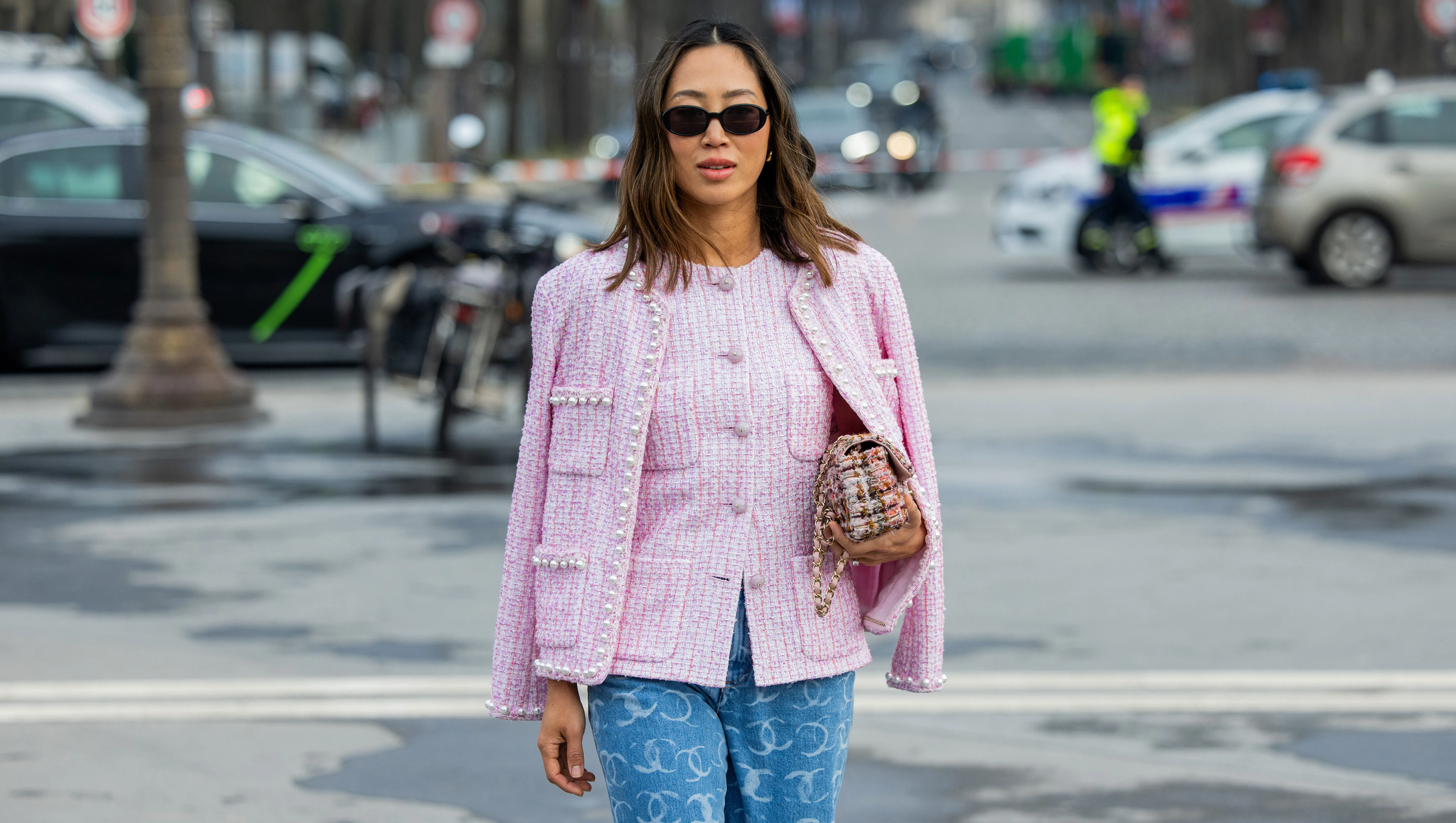 PARIS, FRANCE - MARCH 11: Aimee Song wears pink button up blouse, jacket, denim jeans with logo print, bag, sunglasses outside Chanel during the Womenswear Fall/Winter 2025/2026 as part of Paris Fashion Week on March 11, 2025 in Paris, France. (Photo by Christian Vierig/Getty Images)