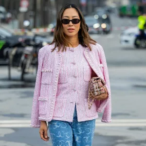 PARIS, FRANCE - MARCH 11: Aimee Song wears pink button up blouse, jacket, denim jeans with logo print, bag, sunglasses outside Chanel during the Womenswear Fall/Winter 2025/2026 as part of Paris Fashion Week on March 11, 2025 in Paris, France. (Photo by Christian Vierig/Getty Images)
