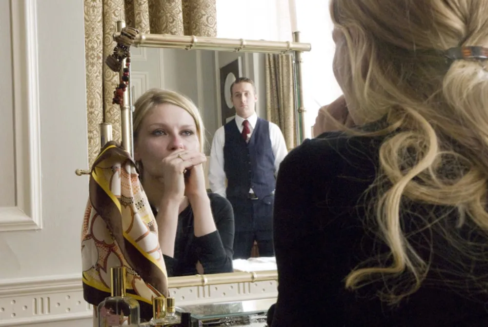 Kirsten Dunst looks in a mirror while Ryan Gosling watches in All Good Things.