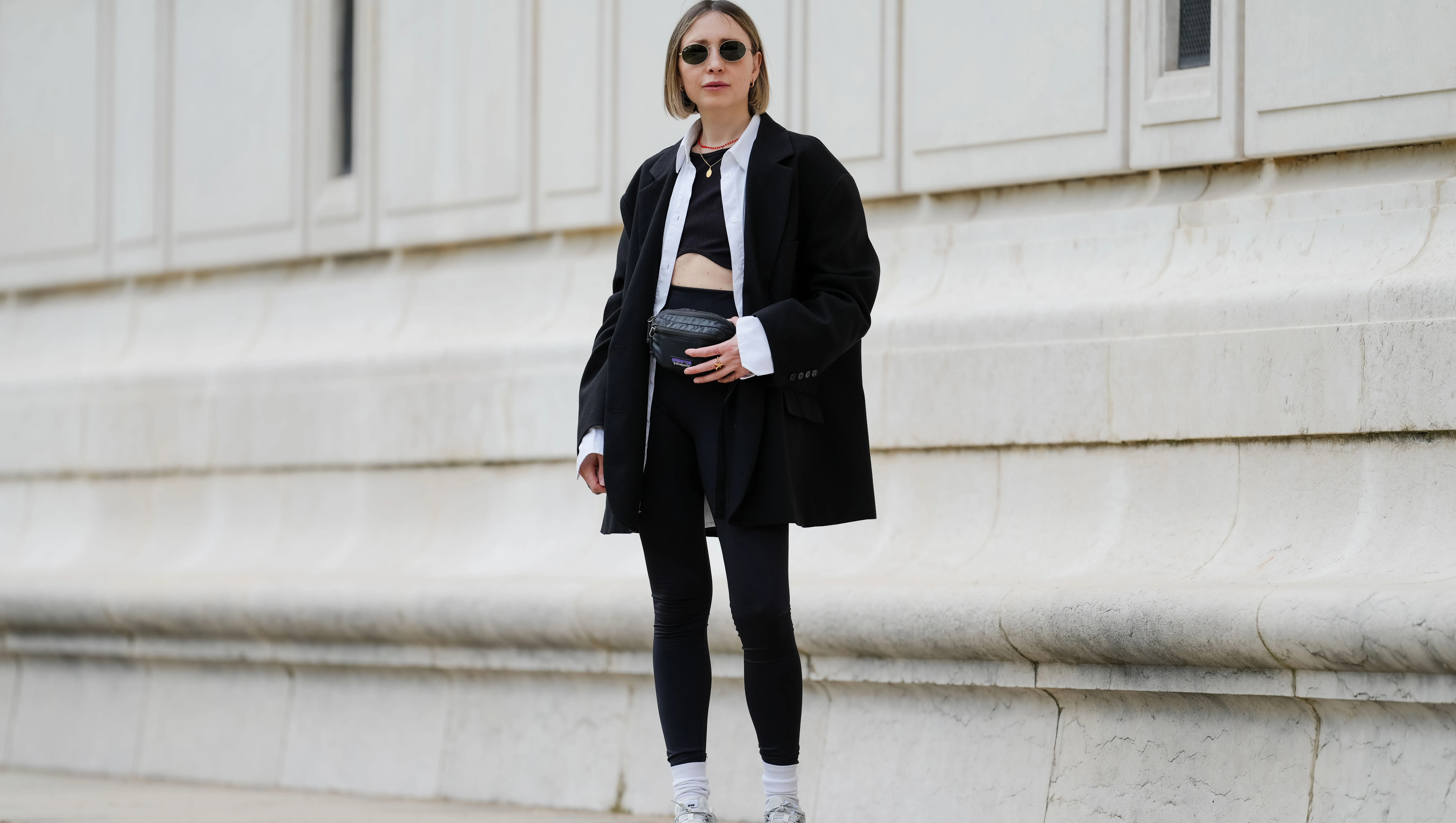 PARIS, FRANCE - MAY 12: Emy Venturini wears sunglasses from Ray Ban, a necklace, a white shirt from Louis Vuitton, a black Zara crop top, a black oversize blazer jacket from The Frankie Shop, black leggings from Intimissimi, white socks from Calzedonia, Nike sneakers shoes, a black leather belt bag / fanny pack from Patagonia, during a street style fashion photo session, on May 12, 2024 in Paris, France. (Photo by Edward Berthelot/Getty Images)