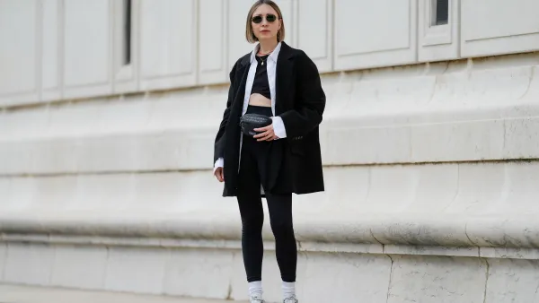 PARIS, FRANCE - MAY 12: Emy Venturini wears sunglasses from Ray Ban, a necklace, a white shirt from Louis Vuitton, a black Zara crop top, a black oversize blazer jacket from The Frankie Shop, black leggings from Intimissimi, white socks from Calzedonia, Nike sneakers shoes, a black leather belt bag / fanny pack from Patagonia, during a street style fashion photo session, on May 12, 2024 in Paris, France. (Photo by Edward Berthelot/Getty Images)