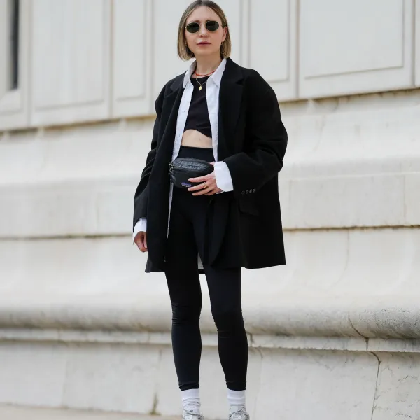 PARIS, FRANCE - MAY 12: Emy Venturini wears sunglasses from Ray Ban, a necklace, a white shirt from Louis Vuitton, a black Zara crop top, a black oversize blazer jacket from The Frankie Shop, black leggings from Intimissimi, white socks from Calzedonia, Nike sneakers shoes, a black leather belt bag / fanny pack from Patagonia, during a street style fashion photo session, on May 12, 2024 in Paris, France. (Photo by Edward Berthelot/Getty Images)