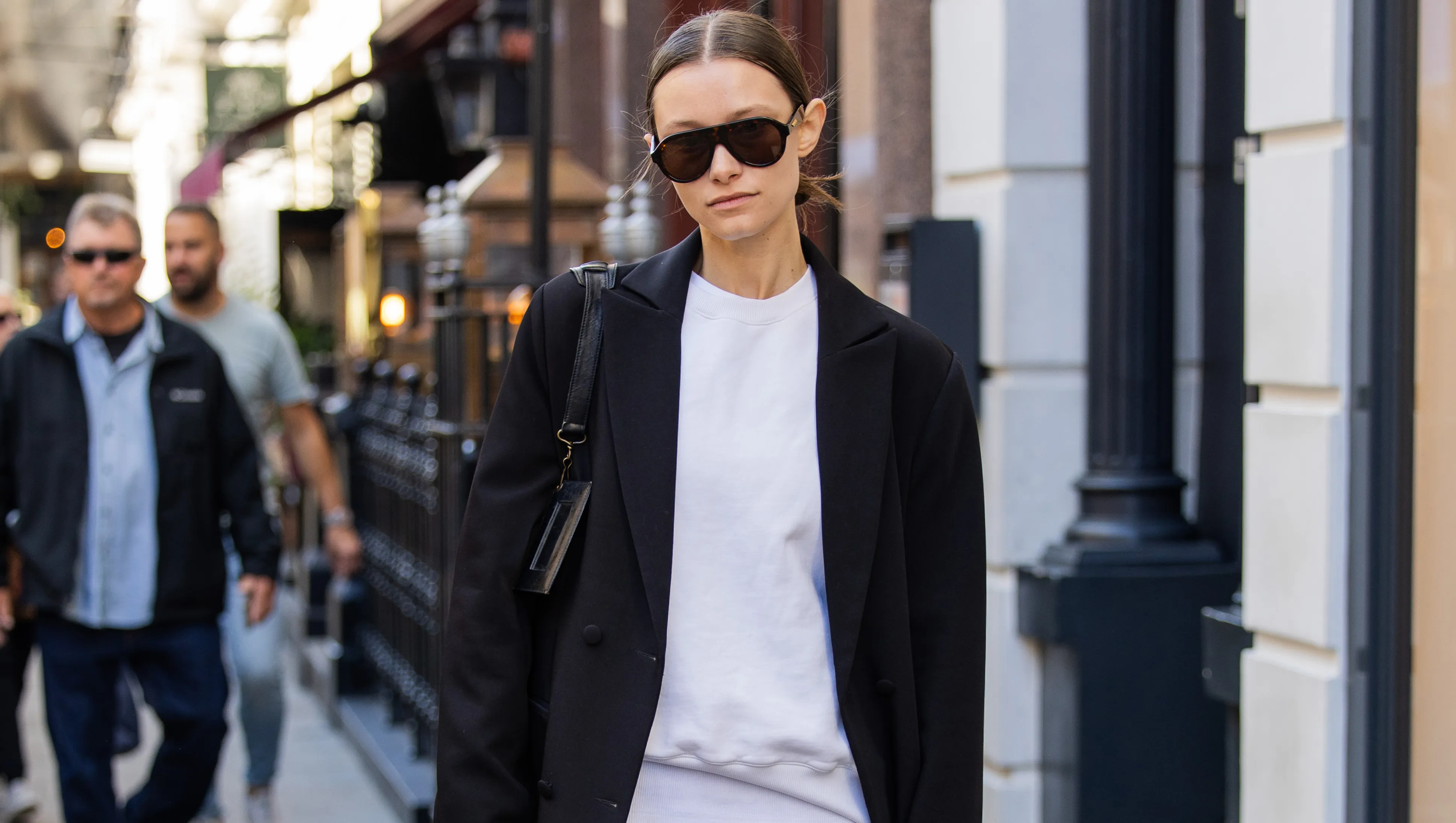 LONDON, ENGLAND - SEPTEMBER 13: A guest wears sequined skirt, black long coat, Balenciaga bag, sunglasses, mid high socks outside Bora Aksu during London Fashion Week September 2024 on September 13, 2024 in London, England. (Photo by Christian Vierig/Getty Images)