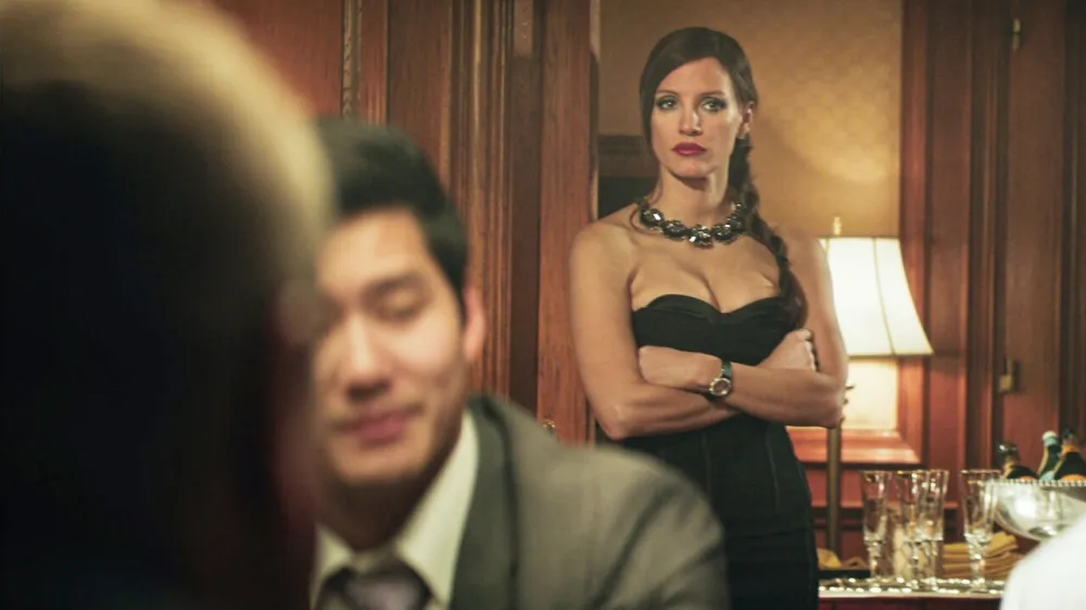 A woman looks at a poker game in Molly's Game.