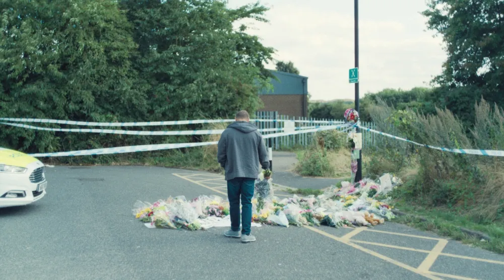 A man stands in a parking lot in Adolescence.