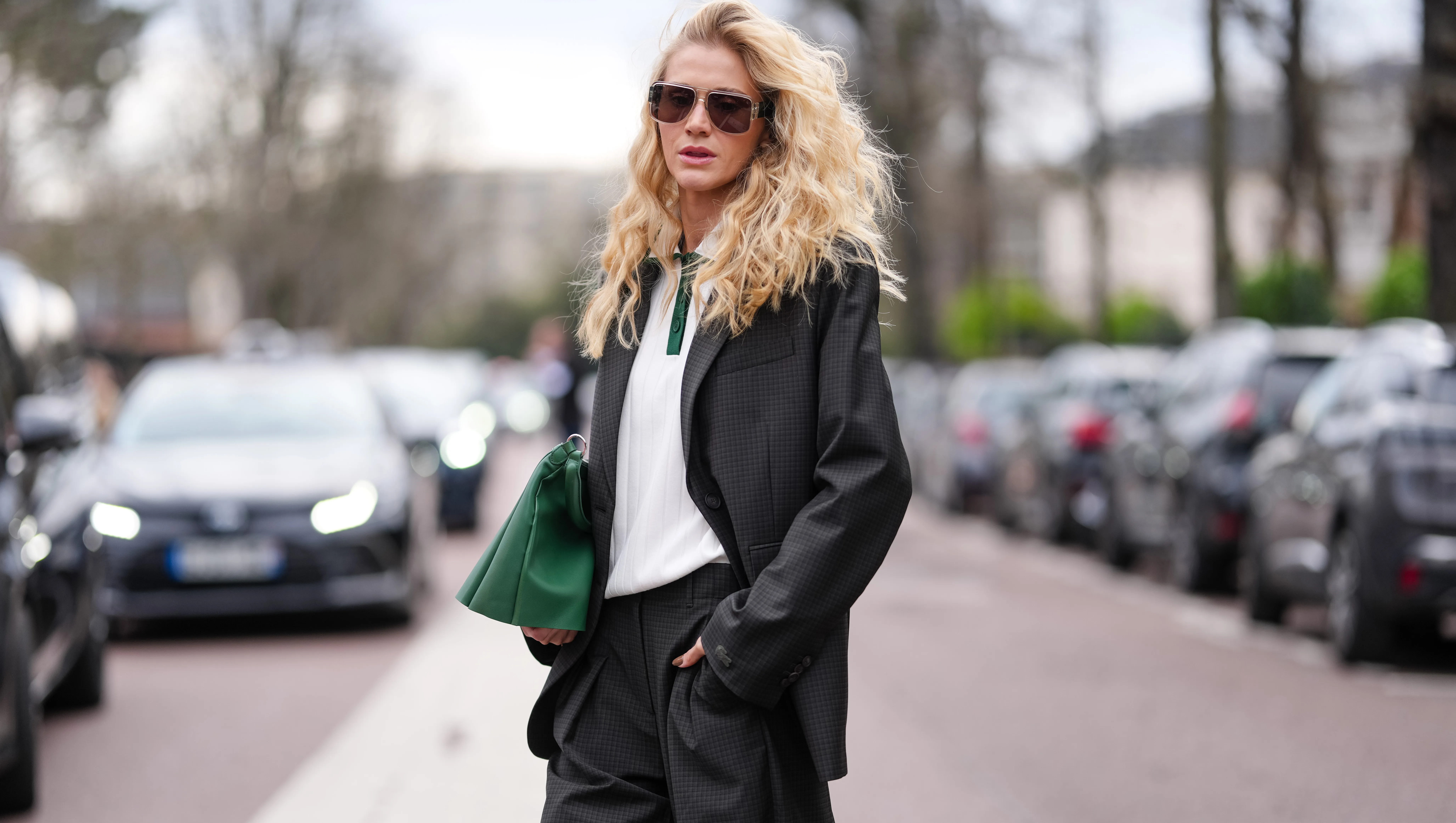PARIS, FRANCE - MARCH 09: Celina Locks wears black sunglasses, white dark green polo shirt, black blazer jacket, shiny dark green Lacoste leather bag, outside Lacoste, during the Paris Fashion week Women's Fall/Winter 2025-2026 on March 9, 2025 in Paris, France. (Photo by Edward Berthelot/Getty Images)