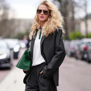 PARIS, FRANCE - MARCH 09: Celina Locks wears black sunglasses, white dark green polo shirt, black blazer jacket, shiny dark green Lacoste leather bag, outside Lacoste, during the Paris Fashion week Women's Fall/Winter 2025-2026 on March 9, 2025 in Paris, France. (Photo by Edward Berthelot/Getty Images)