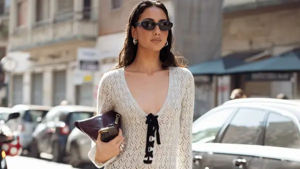 MILAN, ITALY - MARCH 02: A guest wears long crochet white maxi dress, long black boots, dark brown bag outside the Avavav fashion show during the Milan Fashion Week Womenswear Fall/Winter 2025/2026 on March 02, 2025 in Milan, Italy. (Photo by Raimonda Kulikauskiene/Getty Images)