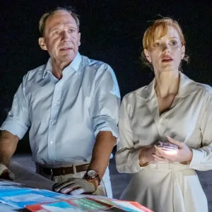 A man and a woman stand by a car at night in The Forgiven.