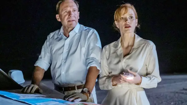 A man and a woman stand by a car at night in The Forgiven.