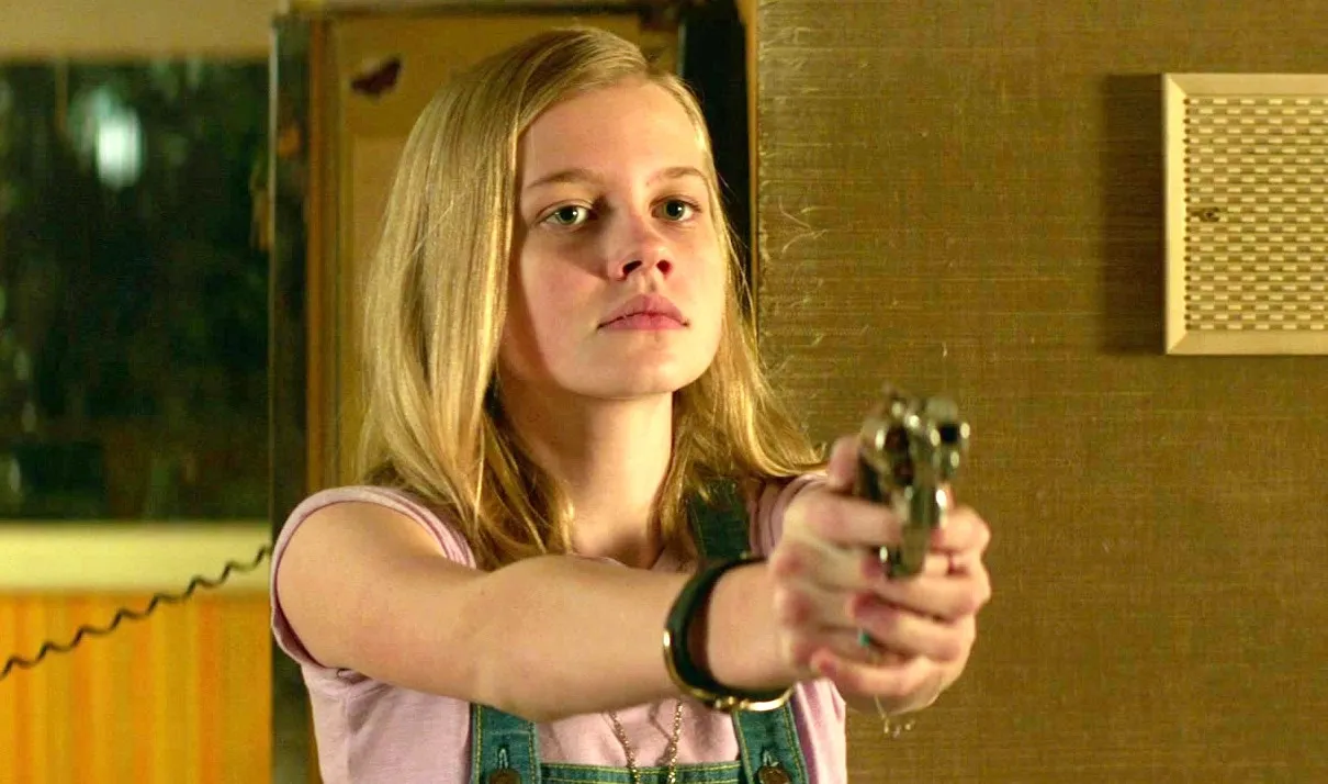 A girl aims a gun in The Nice Guys.