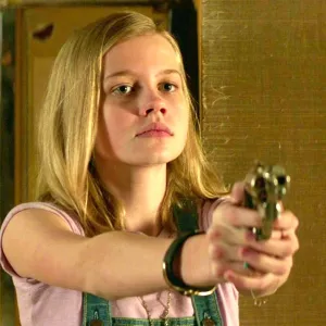 A girl aims a gun in The Nice Guys.