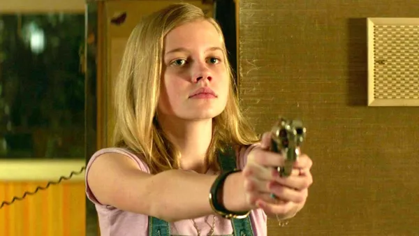 A girl aims a gun in The Nice Guys.