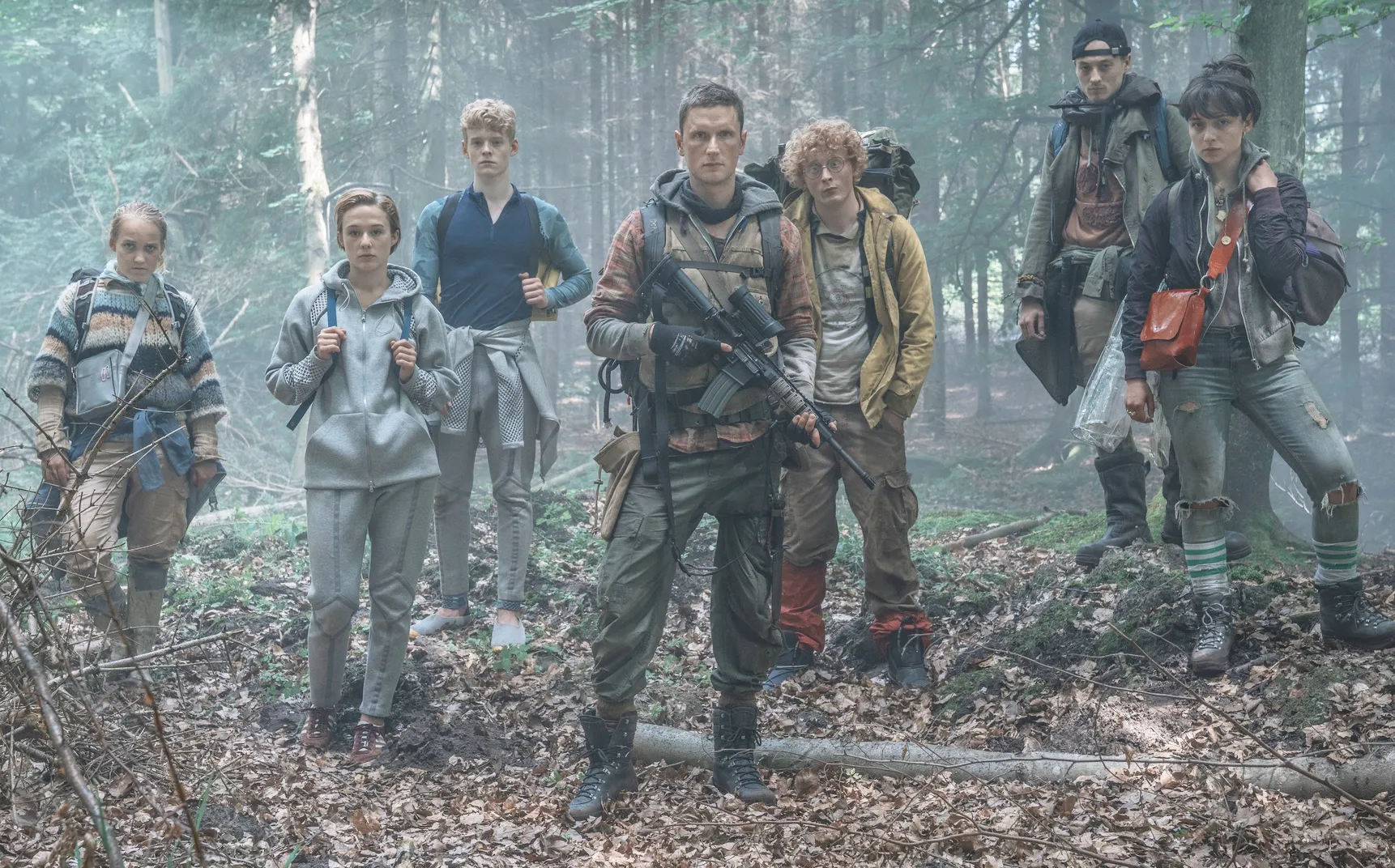 A group of teens stand in the woods in The Rain.