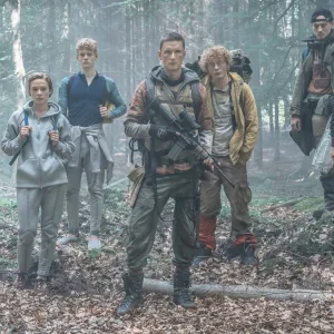 A group of teens stand in the woods in The Rain.