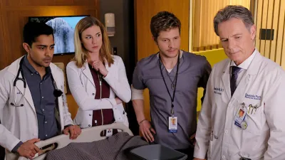 Four doctors stand near a patient's bed in The Resident.