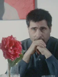 A man sits at a desk in Between the Temples.