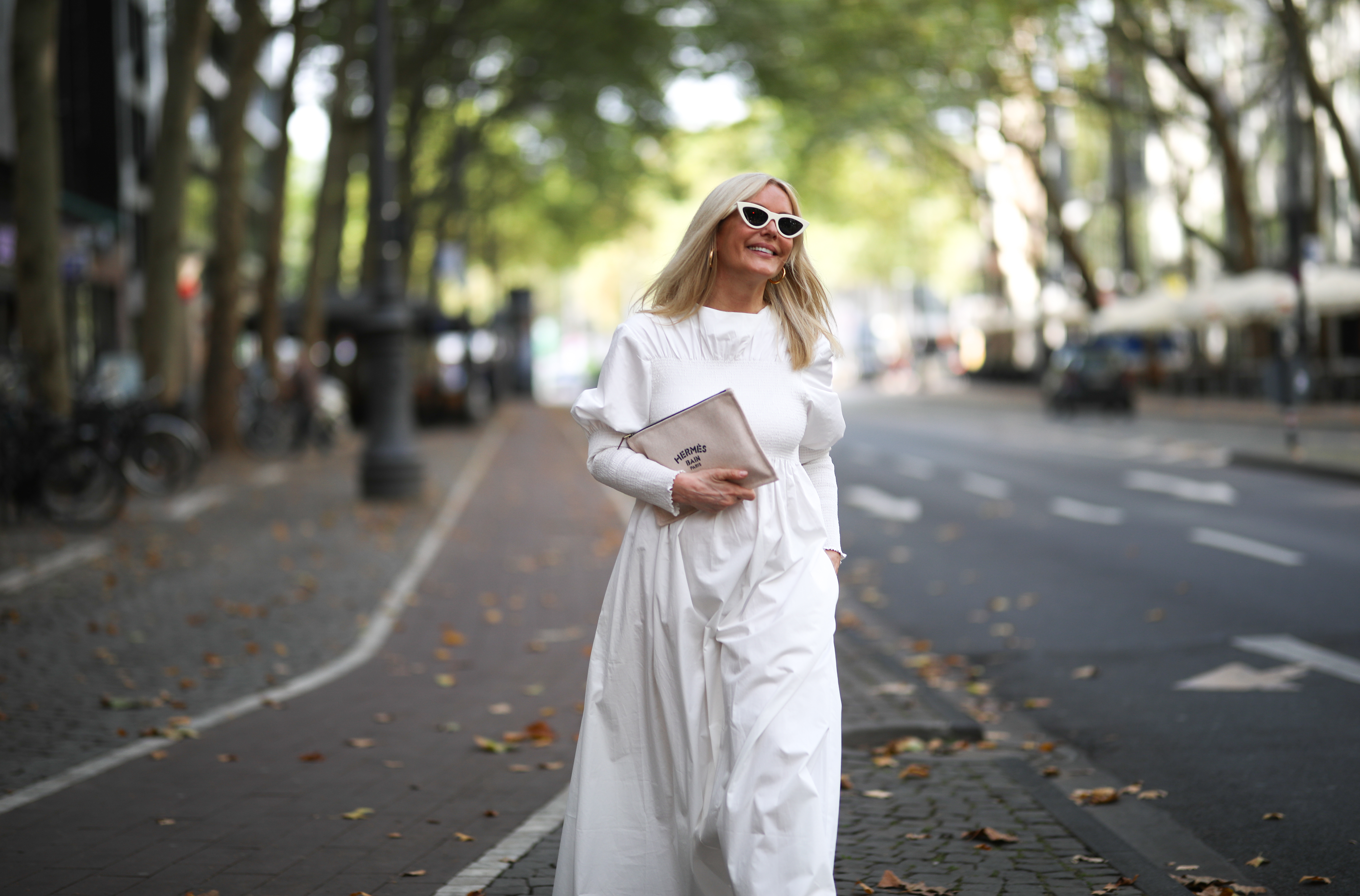 Judith Mosqueira do Amaral wearing Toteme dress, Ariane Ernst earring, Balenciaga sneaker, Hermes clutch and Celine shades on August 14, 2020 in Cologne, Germany.