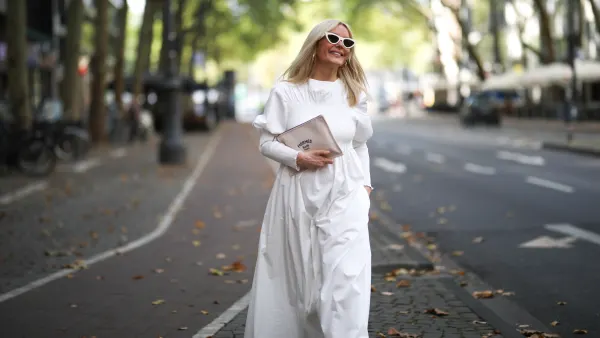 Judith Mosqueira do Amaral wearing Toteme dress, Ariane Ernst earring, Balenciaga sneaker, Hermes clutch and Celine shades on August 14, 2020 in Cologne, Germany.