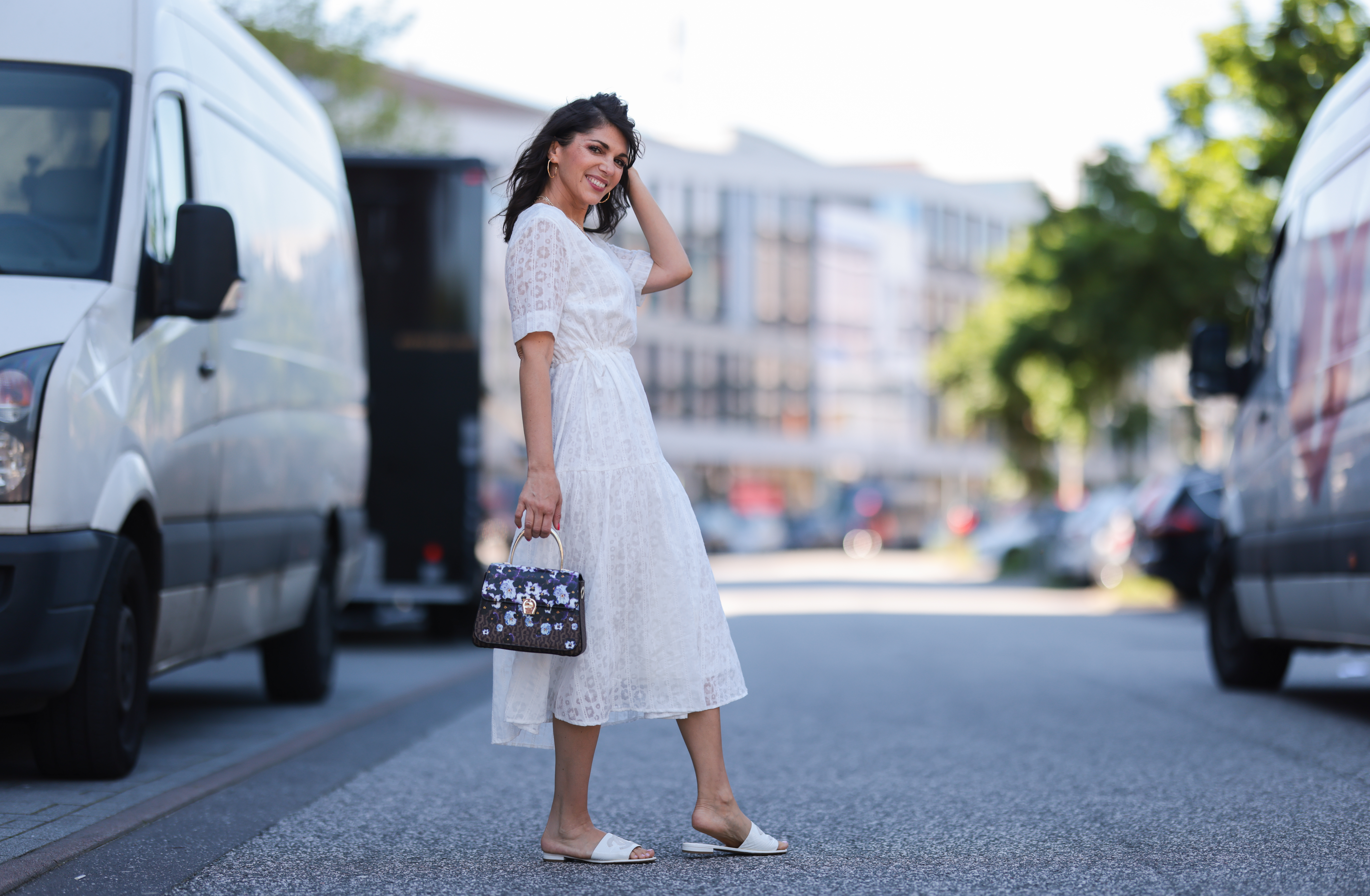 Anna Wolfers wearing white midi dress via Goldig Shop, colorful Aigner Munich bag and white Chanel slides on May 31, 2021 in Hamburg, Germany.