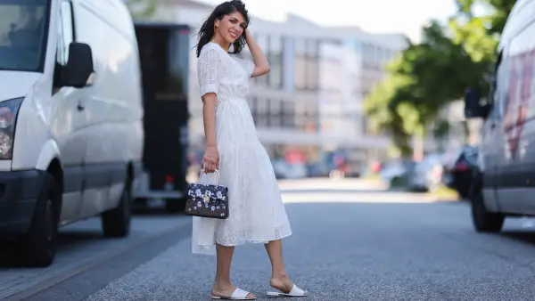 Anna Wolfers wearing white midi dress via Goldig Shop, colorful Aigner Munich bag and white Chanel slides on May 31, 2021 in Hamburg, Germany.