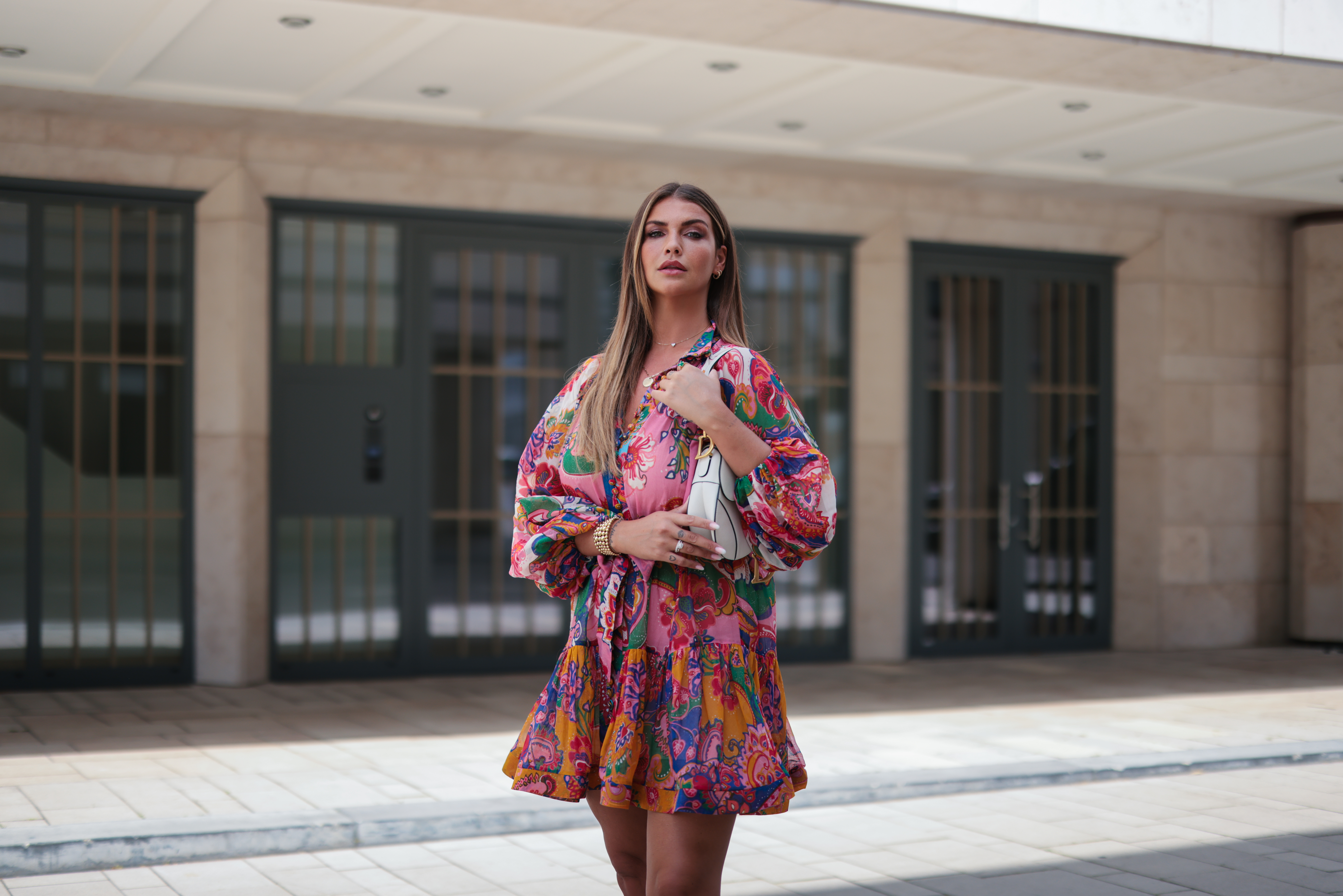 Farina Opoku wearing pink floral Zimmermann mini dress and white Dior saddle bag poses on June 18, 2021 in Cologne, Germany.