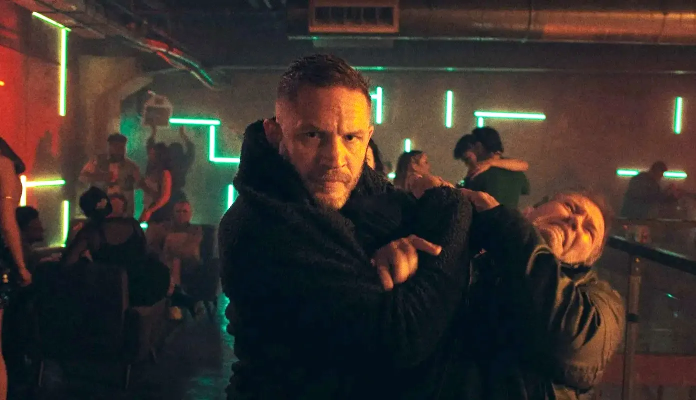 A man holds a gun to another man's head in Havoc.