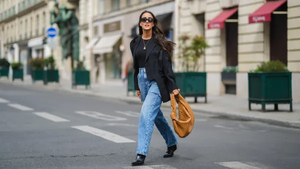 PARIS, FRANCE - APRIL 29: Tamara Kalinic wears black Sestini sunglasses, gold earrings, a black t-shirt, a black oversized ripped Margiela blazer jacket, a gold ring, blue faded denim oversized ripped Margiela jeans pants, a brown shiny leather braided Jodie Petit Bottega Veneta handbag, black shiny leather pointed heels Bottega Veneta ankle boots, on April 29, 2021 in Paris, France. (Photo by Edward Berthelot/Getty Images)