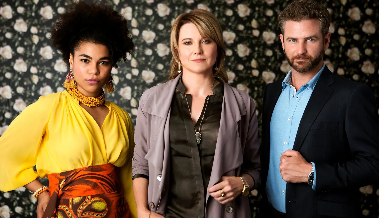 Three people stand and look at the camera in My Life is Murder.