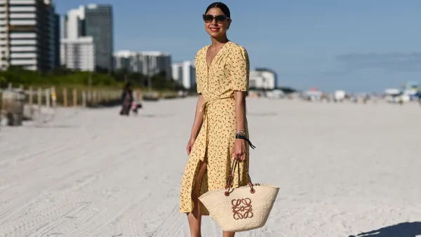 MIAMI, FLORIDA - DECEMBER 01: Sana Rezwan is seen wearing a yellow Rouge dress, Loewe bag and Hermes flats outside UNTITLED Art on December 01, 2021 in Miami, Florida.
