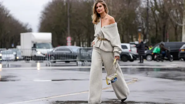 PARIS, FRANCE - JANUARY 28: Xenia Adonts wears silver necklace, light gray oversized Chanel tweed cardigan, light brown suede belt, light gray baggy Chanel tweed pants, light yellow transparent Chanel bag, outside Chanel, during the Haute Couture Spring/Summer 2025 on January 28, 2025 in Paris, France. (Photo by Edward Berthelot/Getty Images)