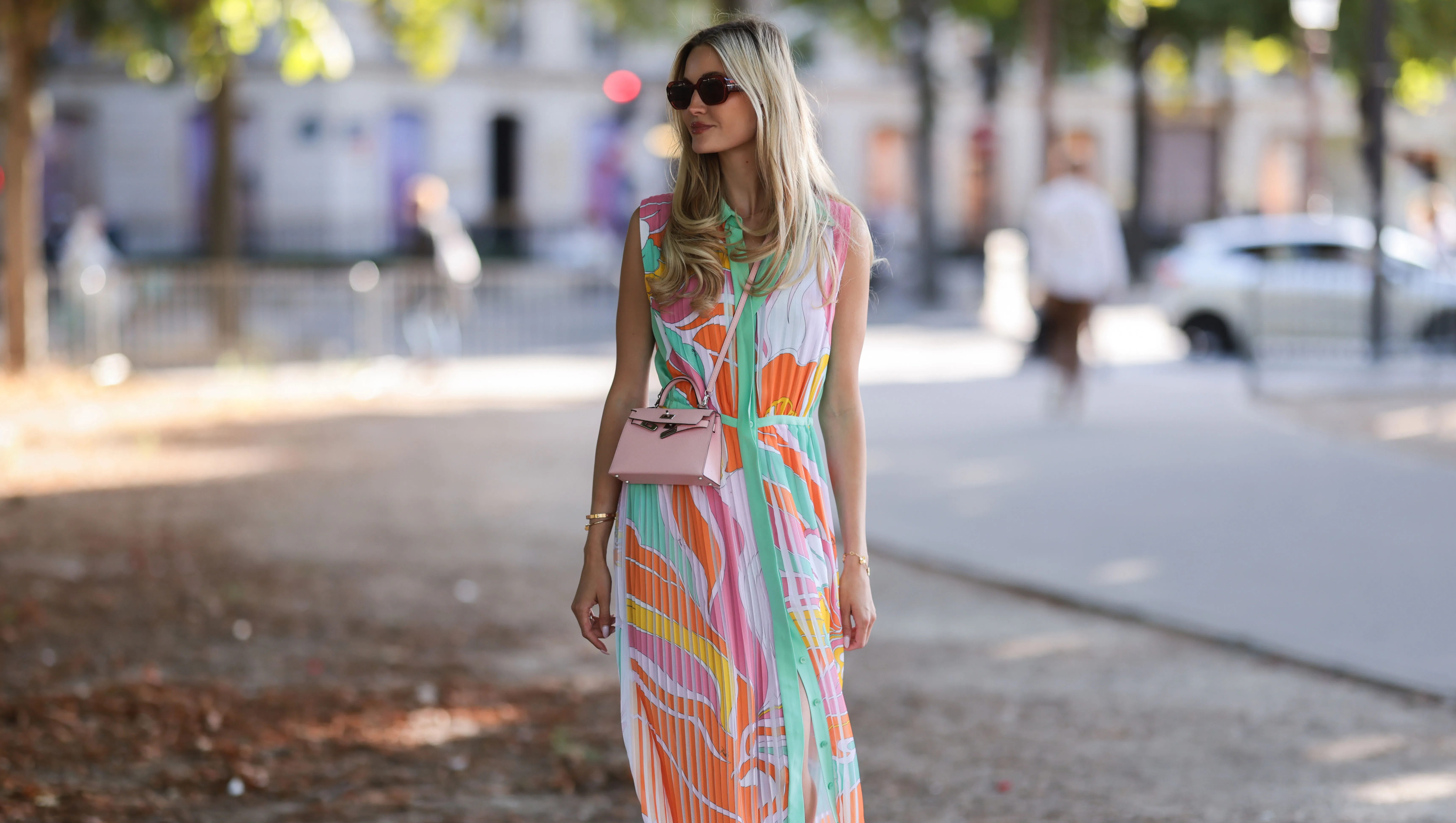 PARIS, FRANCE - JULY 06: Mandy Bork seen wearing brown sunglasses from Tom Ford, a colorful buttoned / pleated / sleeveless long dress from Emilio Pucci, a pale pink Hermes Kelly mini bag and white creme sandals from Chanel, during Paris Fashion Week - Haute Couture Fall Winter 2022 2023, on July 06, 2022 in Paris, France. (Photo by Jeremy Moeller/Getty Images)