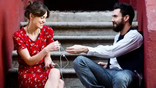 A man and a woman talk outside in Begin Again.
