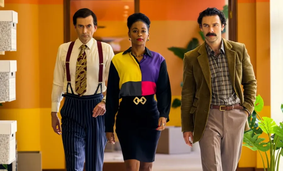 Three people walk down a hallway in Rivals.