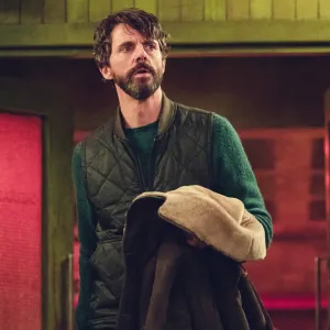 A man holds his coat in Dept. Q.