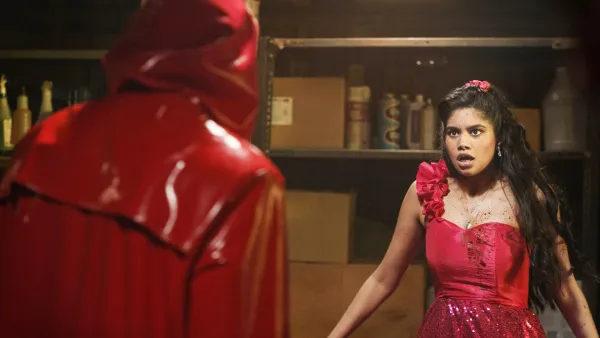 A girl looks at a masked stranger in Fear Street: Prom Queen.